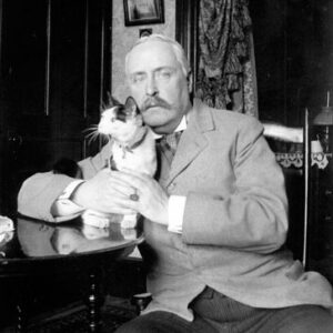 An older man with a mustache holds a cat in a historical photo. Columbia County Historical Society, New York.